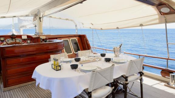 An elegant dining table on the aft deck of Gulet Liberte 11, with a view of the sea.